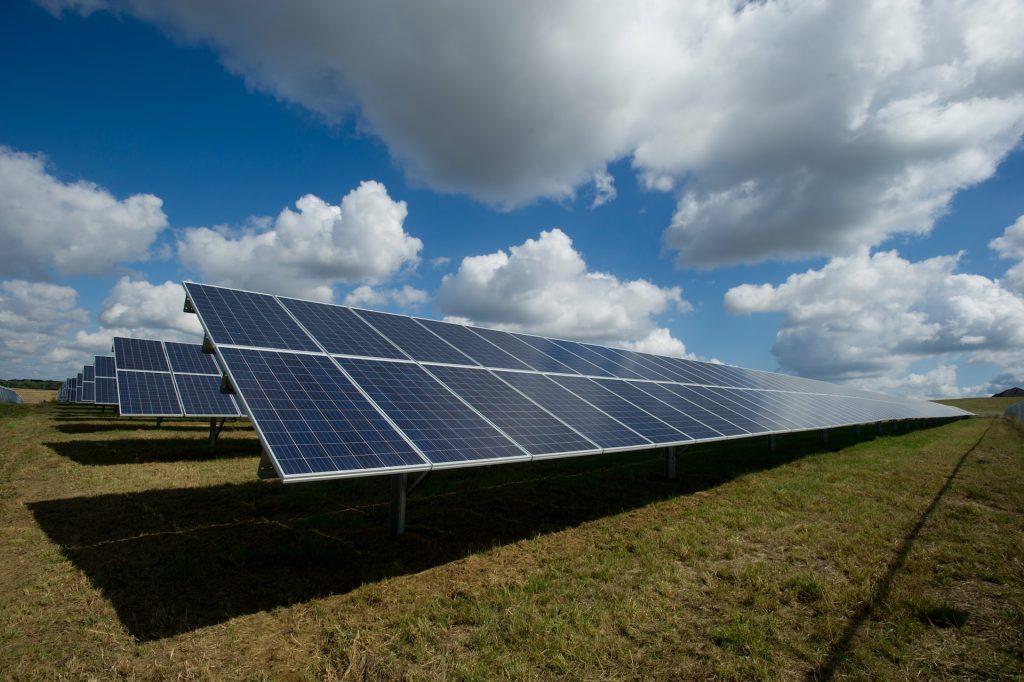 Ground-mounted commercial solar panels under a bright blue sky in Gauteng, installed by Aris Energy